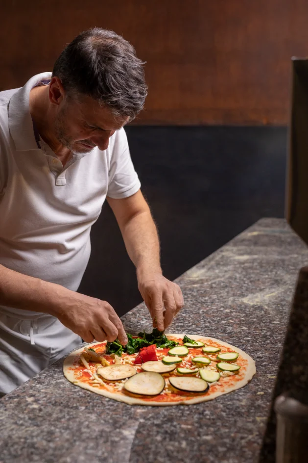 Chef de Olivia preparando pizza artesanal
